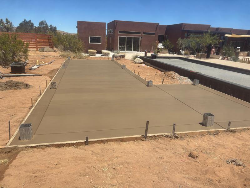 Patio slab with post bases by Dig Deep Concrete